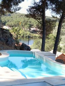 a swimming pool with a view of the water at La Senda del Lago PISCINA PRIVADA in Córdoba +13 photos