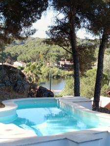 a swimming pool with a view of a river at La Senda del Lago PISCINA PRIVADA in Córdoba