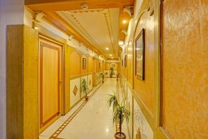 a hallway with yellow walls and a tile floor at Collection O Dandiya Bazar Formerly Vrundavan Residency in Vadodara