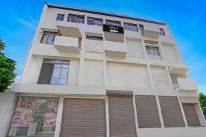 a white building with shutters on it at Collection O Dandiya Bazar Formerly Vrundavan Residency in Vadodara +30 photos