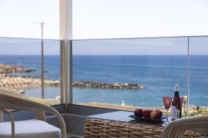 a table with a plate of fruit and wine glasses at MGM Suites in Panormos Rethymno