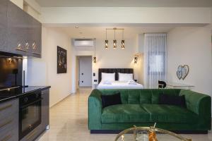 a living room with a green couch and a bed at MGM Suites in Panormos Rethymno
