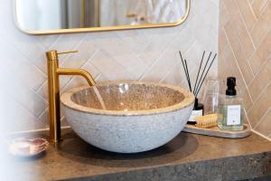 a bathroom with a bowl sink and a gold faucet at Strandflickornas Husen invid Havet in Lysekil