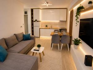 a living room with a couch and a table and a kitchen at Apartman Centar Paracin in Paraćin