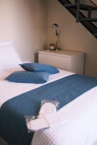 a bedroom with two beds with blue and white pillows at Casa Delfina - Bergamo in Torre Boldone