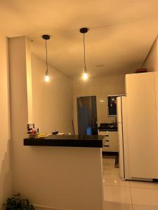 a kitchen with a counter and a refrigerator at Aconchego e conforto in Bom Jesus da Lapa +2 photos