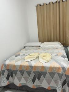 a bedroom with a bed with two hats on it at Aconchego e conforto in Bom Jesus da Lapa