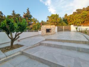 a stone patio with stairs and a tree at Aroma Zia Residences in Lagoúdi Zía