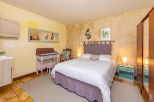 a bedroom with a large bed and a desk at L'instant ROSE - Escapade Champêtre in Grazac