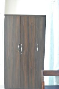 a wooden cabinet with two doors in a room at Magpie Residency Kalimpong in Kalimpong +27 photos