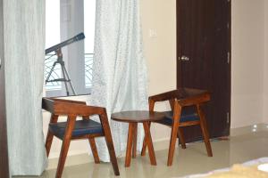 two chairs and a table in a room at Magpie Residency Kalimpong in Kalimpong