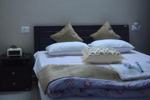 a bedroom with a bed with pillows on it at Magpie Residency Kalimpong in Kalimpong