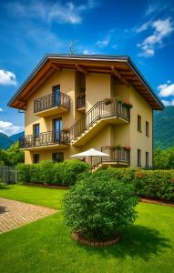 a large building with balconies and a green yard at ValtellinaSuite in Villa di Tirano