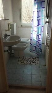 La salle de bains est pourvue de 2 lavabos et d'un rideau de douche. dans l'établissement BILOCALE Villa Gioello, à Cesenatico