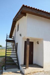 een trap naar een wit gebouw met een deur bij Vila Lotus in Murighiol