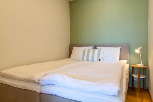 a bed with white sheets and pillows in a room at TEN Apartments - Kuressaare in Kuressaare