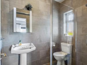 a bathroom with a sink and a toilet and a mirror at Paddy Carrolls Cottage in Ballyconneely +81 photos
