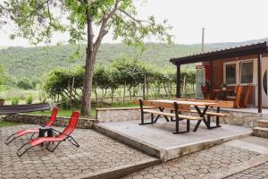 a picnic table and two chairs in front of a cabin at Vikendica Trebižat river in Čapljina