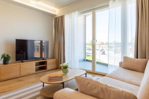a living room with a couch and a tv at TEN Apartments - Kuressaare in Kuressaare