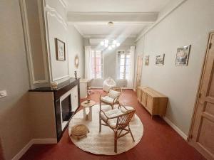 a living room with a chair and a fireplace at Le Régent - Perpignan city center in Perpignan