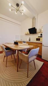 a kitchen with a table and chairs and a refrigerator at Le Régent - Perpignan city center in Perpignan +24 photos