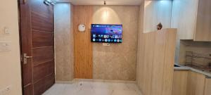 a bathroom with a tv on the wall next to a door at Yogvan Luxury 1BHK Apartments Tapovan Rishikesh in Rishīkesh +133 photos