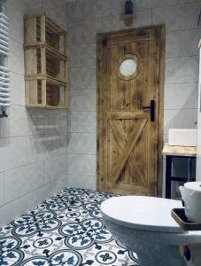 a bathroom with a wooden door and a white tub at Noclegi Na Końcu Świata Bielpon in Przemyśl +62 photos