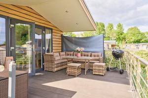 a patio with a couch and chairs and a stage at Ferienhaus "Ostseeperle" mit kostenfreier Saunanutzung, Grundstück Umzäunt in Scharbeutz