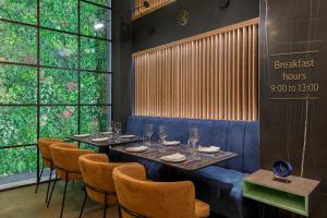 a dining room with tables and chairs and windows at Garment District Suites in Athens