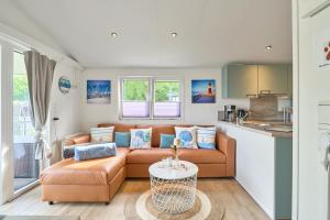 a living room with a couch and a table at Ferienhaus "Ostseeperle" mit kostenfreier Saunanutzung, Grundstück Umzäunt in Scharbeutz