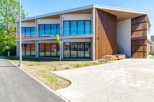 a large building with glass windows on a street at TEN Apartments - Kuressaare in Kuressaare