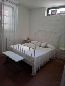 a bedroom with a white bed and a bench at Oasi della Calvana in Vaiano