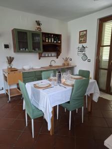a kitchen with a table and green chairs at Oasi della Calvana in Vaiano