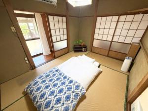 a bedroom with a bed in a room with windows at 別邸 先山 in Kamikatetsu