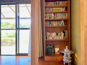 a book shelf filled with books next to a window at 別邸 先山 in Kamikatetsu