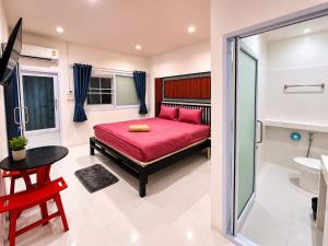 a bedroom with a red bed and a bathroom at Dive In Koh Tao in Ko Tao