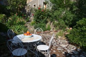 einen Tisch und Stühle mit einer Schüssel Orangen darauf in der Unterkunft Apartment the Haven in Cucugnan