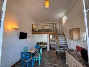 a room with a table and chairs and a loft at Βαχος rooms 3 in Areopoli