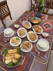 a table with plates of food on top of it at Silk Road Hostel in Bukhara