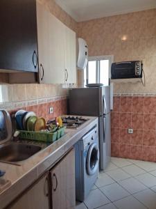 a kitchen with a sink and a washing machine at Families Apartment in Martil