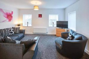 a living room with two couches and a flat screen tv at Skinningrove Beach House 1 in Skinningrove