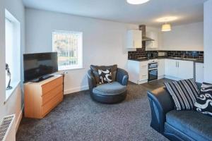 a living room with a couch and a tv and a kitchen at Skinningrove Beach House 1 in Skinningrove