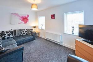 a living room with a couch and a flat screen tv at Skinningrove Beach House 1 in Skinningrove