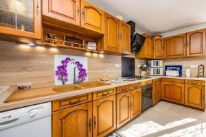a kitchen with wooden cabinets and a sink at L'instant ROSE - Escapade Champêtre in Grazac +8 photos