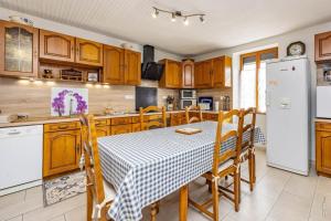 a kitchen with a table and a white refrigerator at L'instant ROSE - Escapade Champêtre in Grazac
