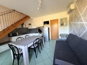 a kitchen and dining room with a table and chairs at Residence Sole e Mare appartamenti in Rosolina Mare