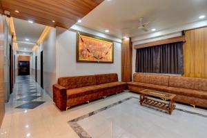 a living room with a couch and a table at Hotel Joy in Chākan