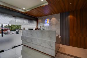 a lobby with a marble counter with a sign on it at Hotel Joy in Chākan