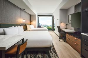 a hotel room with two beds and a desk at Apiary Hotel Belleview Station Denver in Denver +82 photos