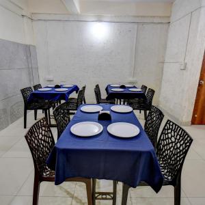 a dining room with blue tables and chairs at Hotel Joy in Chākan